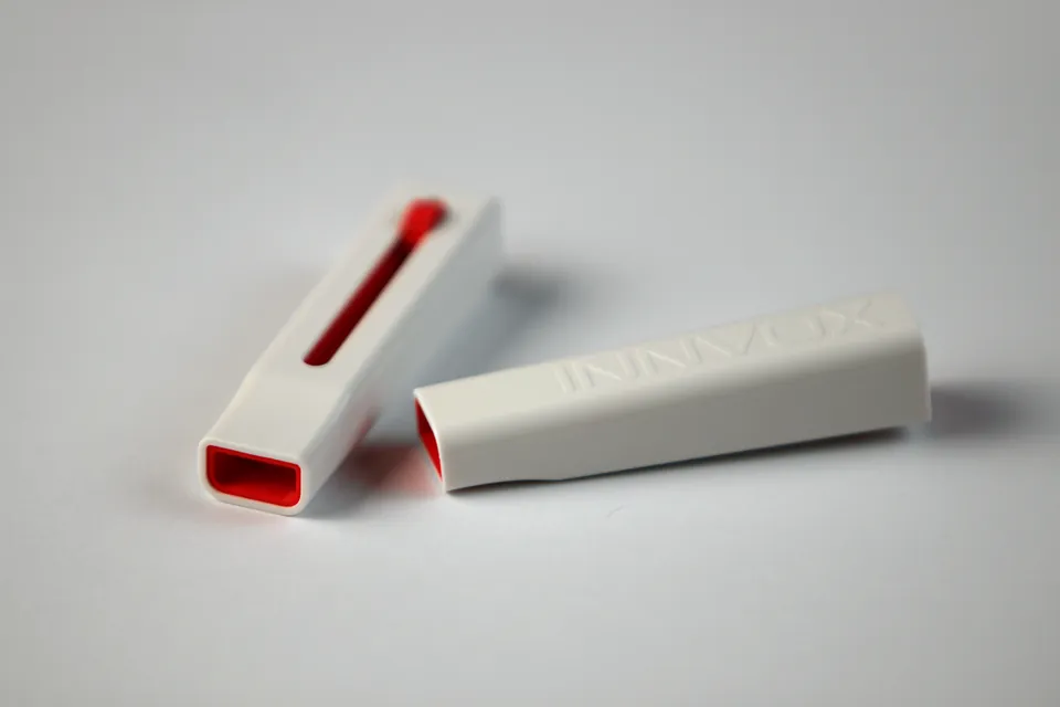 Two INNVOX whistle pieces showing red openings.