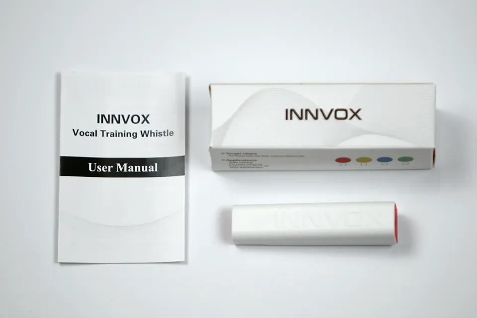 INNVOX box, user manual, and vocal training whistle laid out flat.